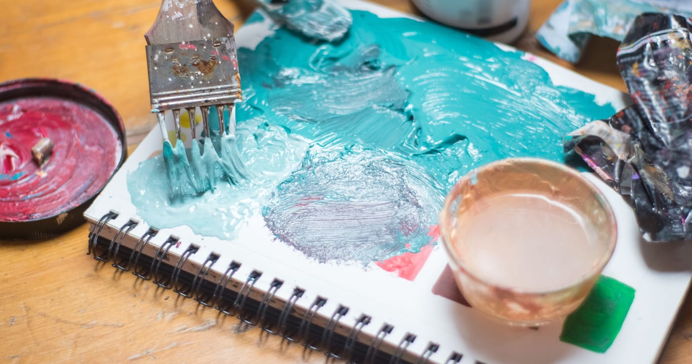 Pincel y pintura sobre un cuaderno de arte